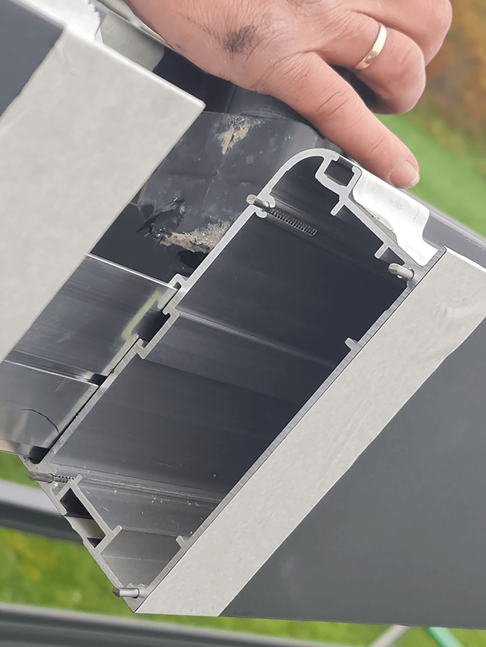 Eine Person mit einem Ring am Finger hält ein Stück Metall