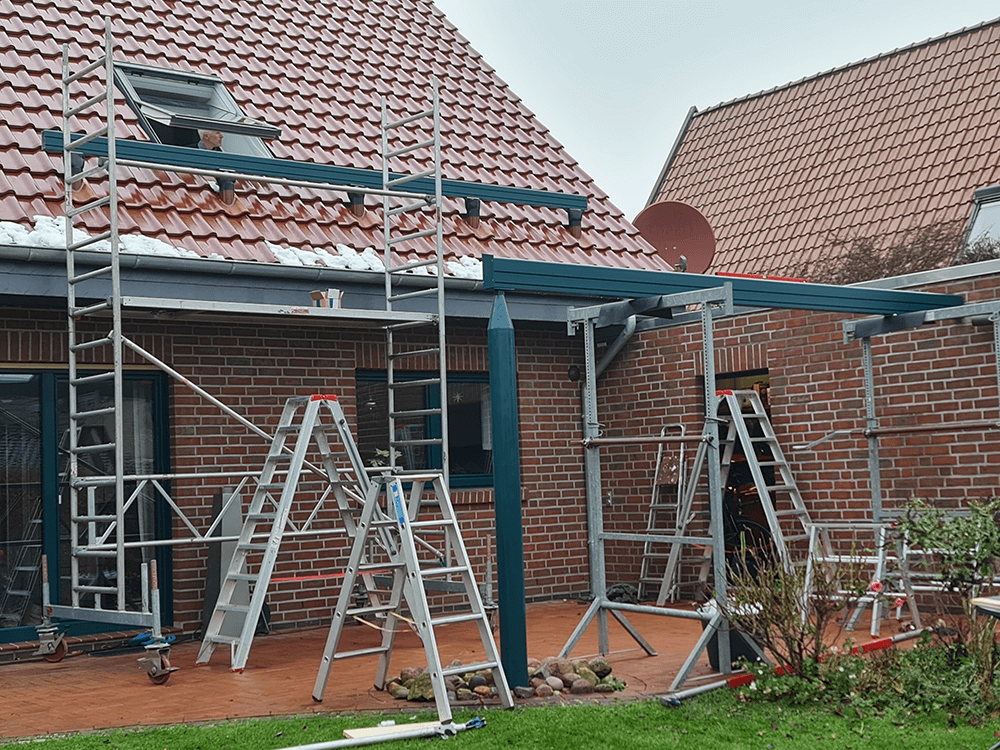 Ein Backsteinhaus mit Gerüsten und Leitern davor.