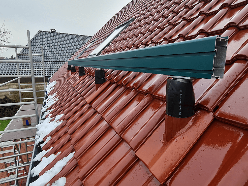 Ein rotes Ziegeldach mit einem blauen Geländer darauf