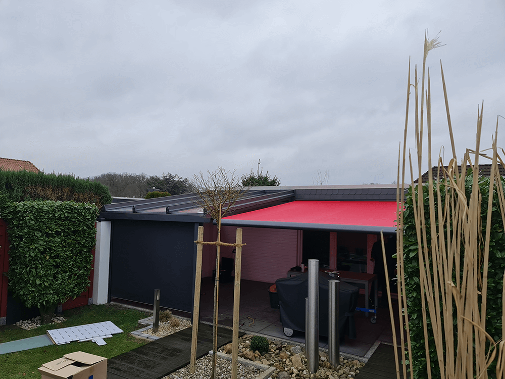 Ein Haus mit einer roten Markise an der Seite.