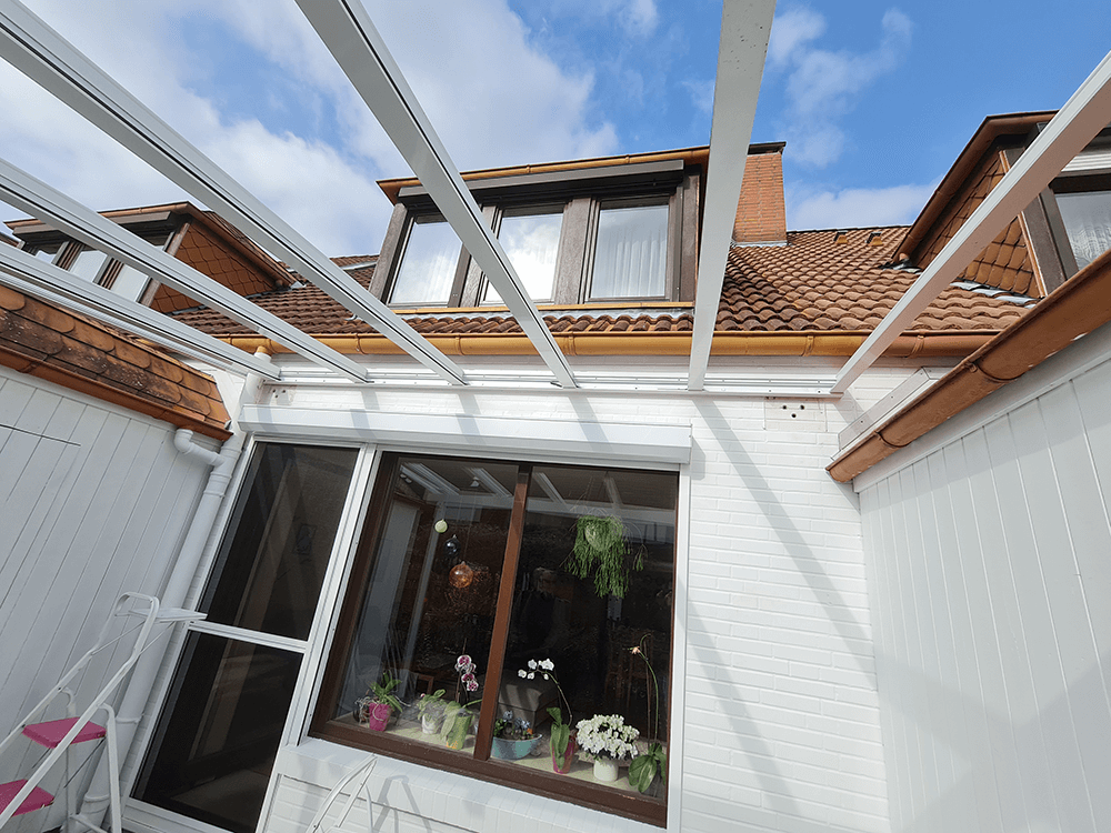 Ein weißes Haus mit einem Glasdach und einem Fenster