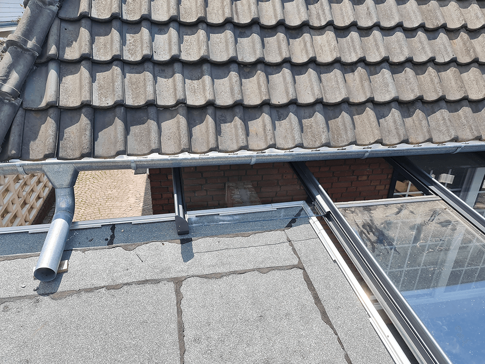 Ein Dach mit einer Dachrinne und einem Fenster darauf