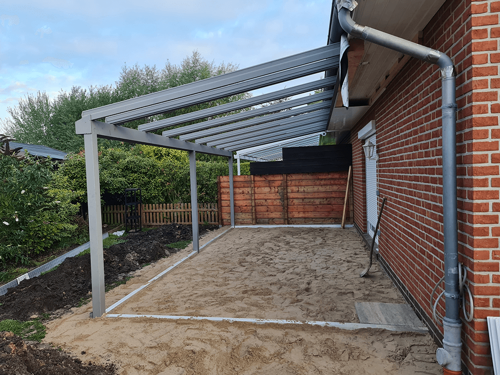 Ein Backsteinhaus mit einer überdachten Terrasse davor.