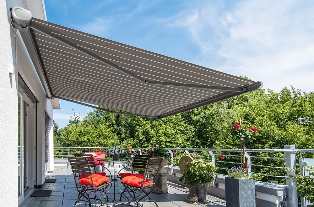 Ein Balkon mit Tisch und Stühlen unter einer Markise.