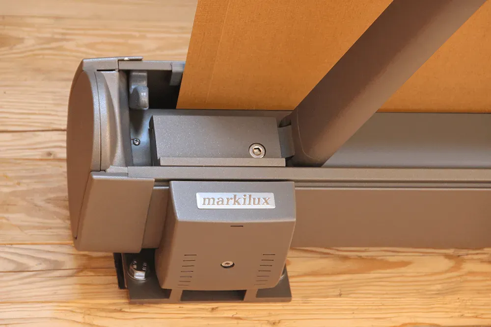 Auf einem Holzboden steht eine graue Schachtel mit der Wortmarke „Flex“.