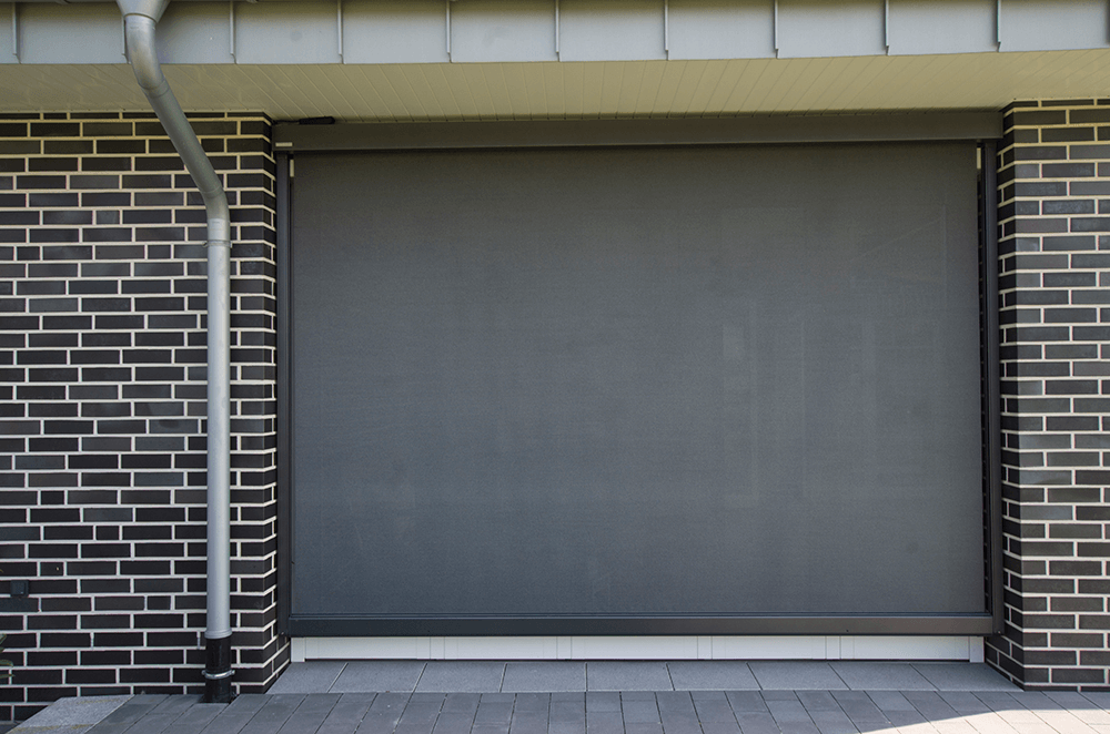 Ein Backsteingebäude mit einem grauen Garagentor