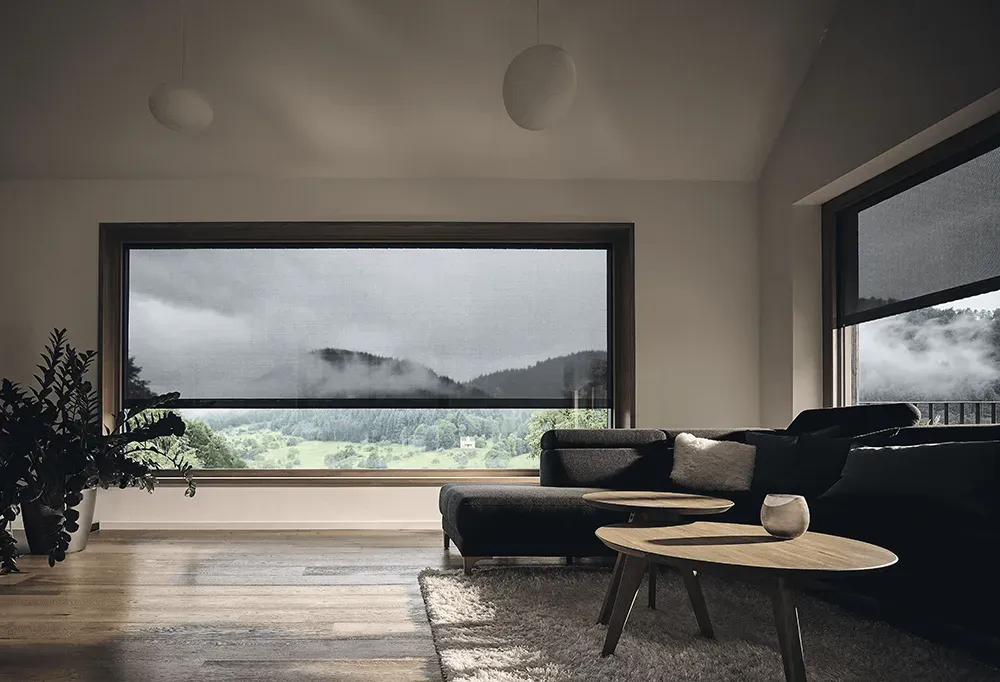 Ein Wohnzimmer mit großem Fenster und Blick auf einen Berg.