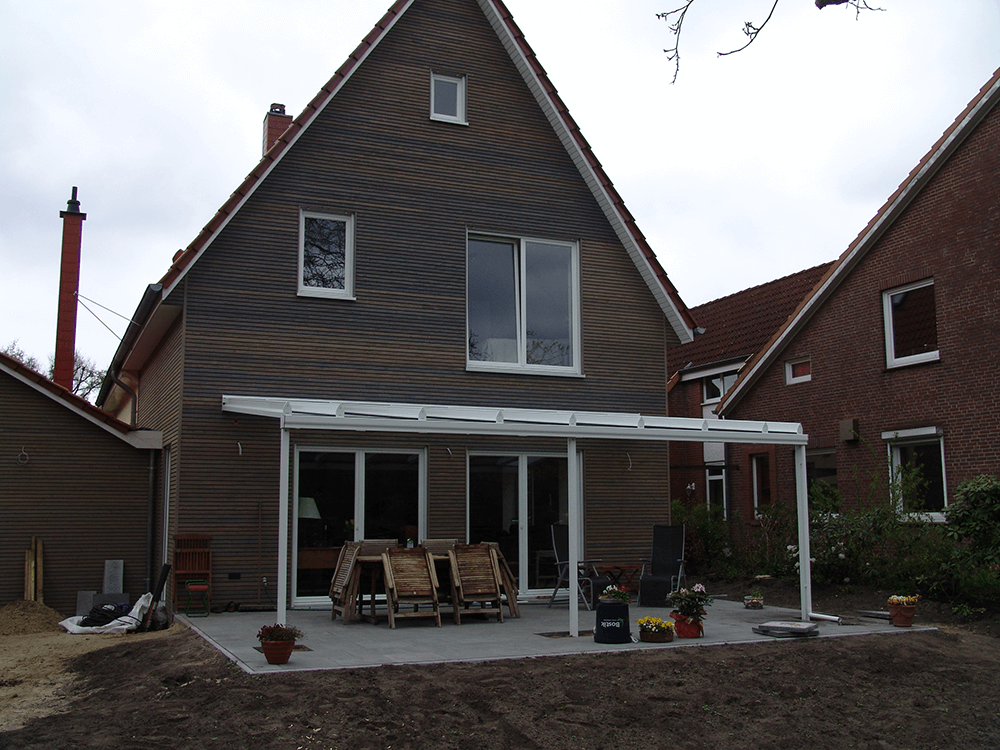 Die Rückseite eines Hauses mit einer weißen Markise über der Terrasse