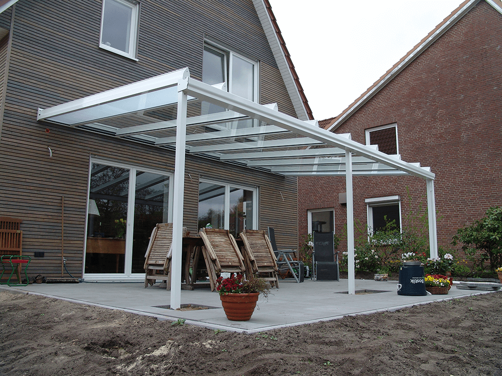 Eine Terrasse mit Tisch und Stühlen unter einem Baldachin