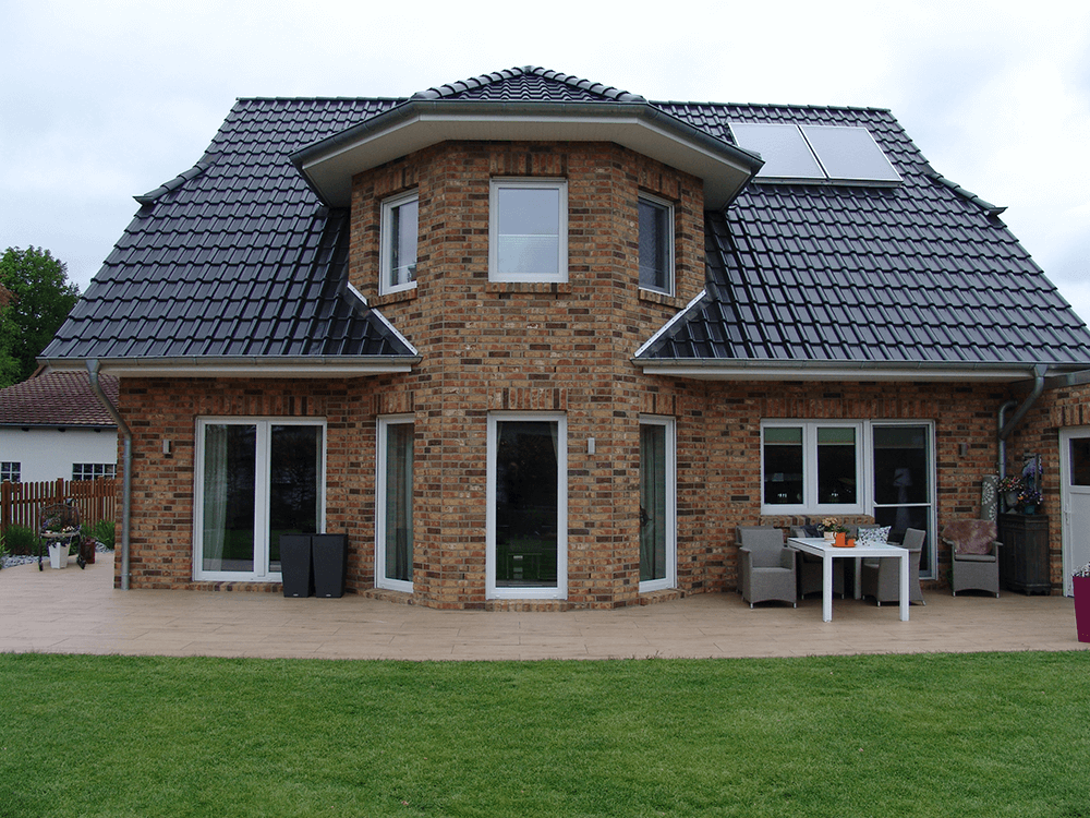 Ein großes Backsteinhaus mit einem schwarzen Dach