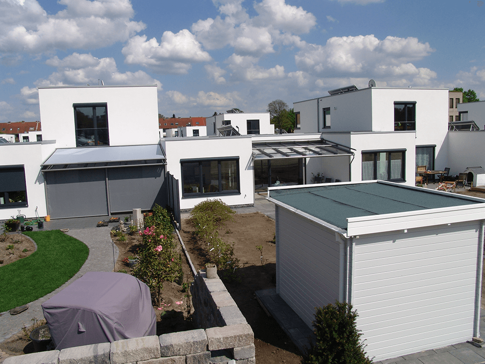 Eine Reihe weißer Häuser mit grünem Dach