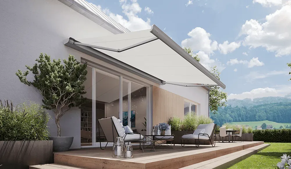 Ein Haus mit einer großen Terrasse mit einer weißen Markise darüber.