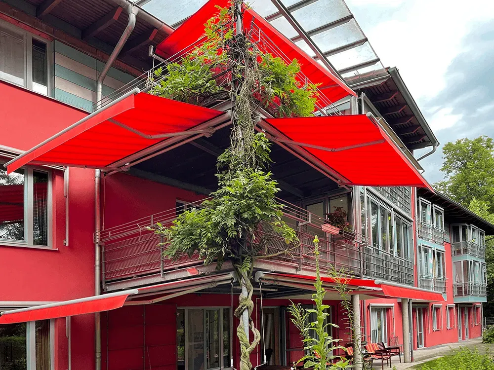 Ein rotes Gebäude mit einer roten Markise auf dem Balkon.
