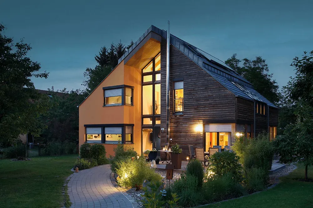 Ein Haus mit vielen Fenstern ist nachts beleuchtet