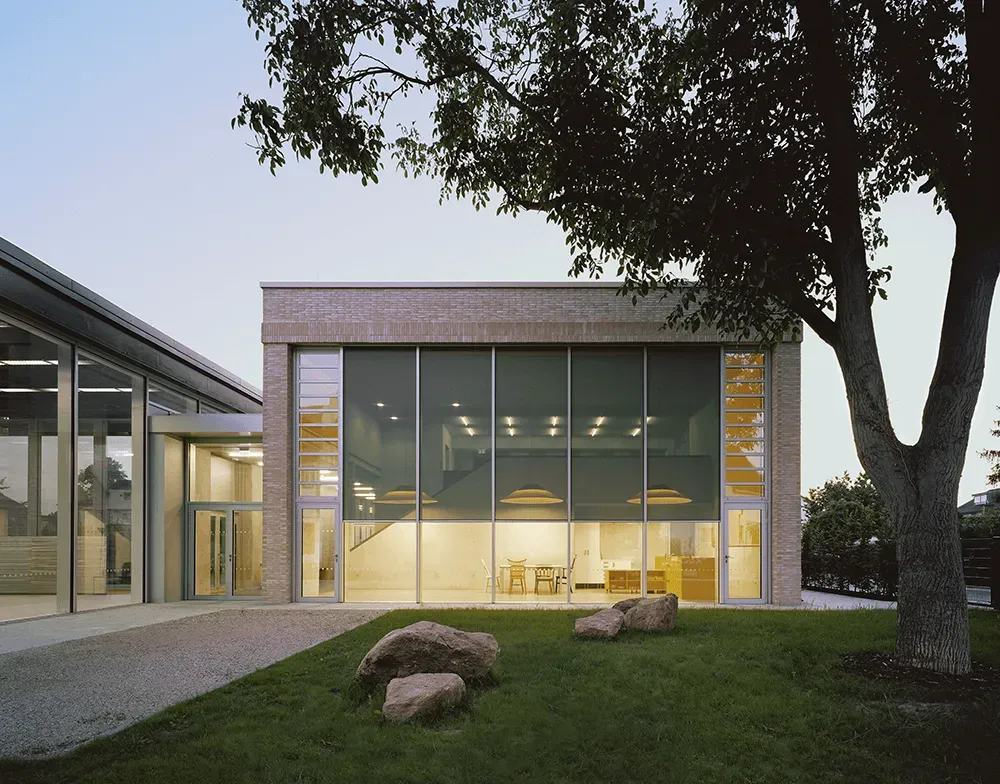 Ein großes Gebäude mit vielen Fenstern und einem Baum davor