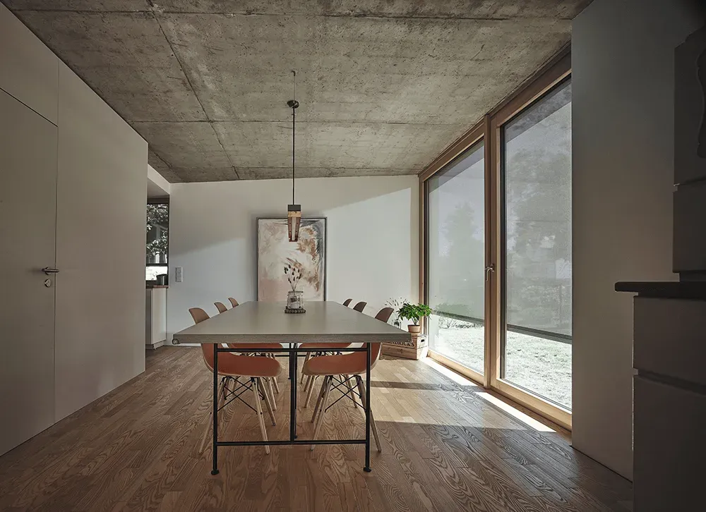 Ein Esszimmer mit Tisch und Stühlen und einem großen Fenster