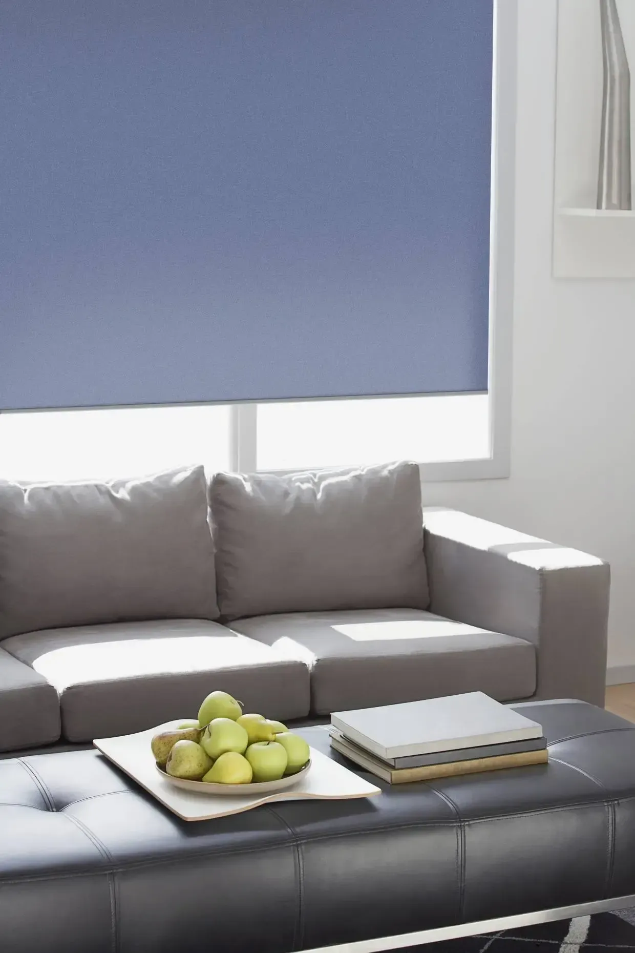 Ein Wohnzimmer mit einer Couch und einem Tisch mit einer Schale Äpfel darauf