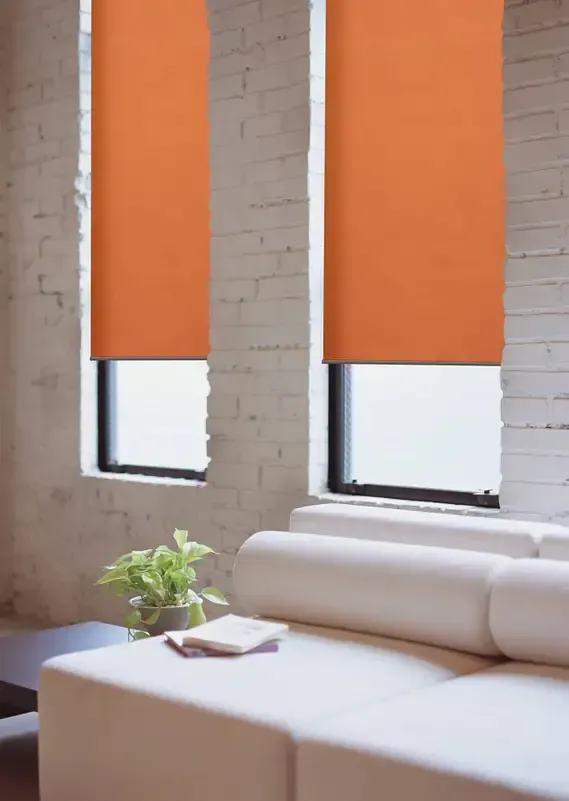 Ein Wohnzimmer mit orangefarbenen Jalousien und einer weißen Couch