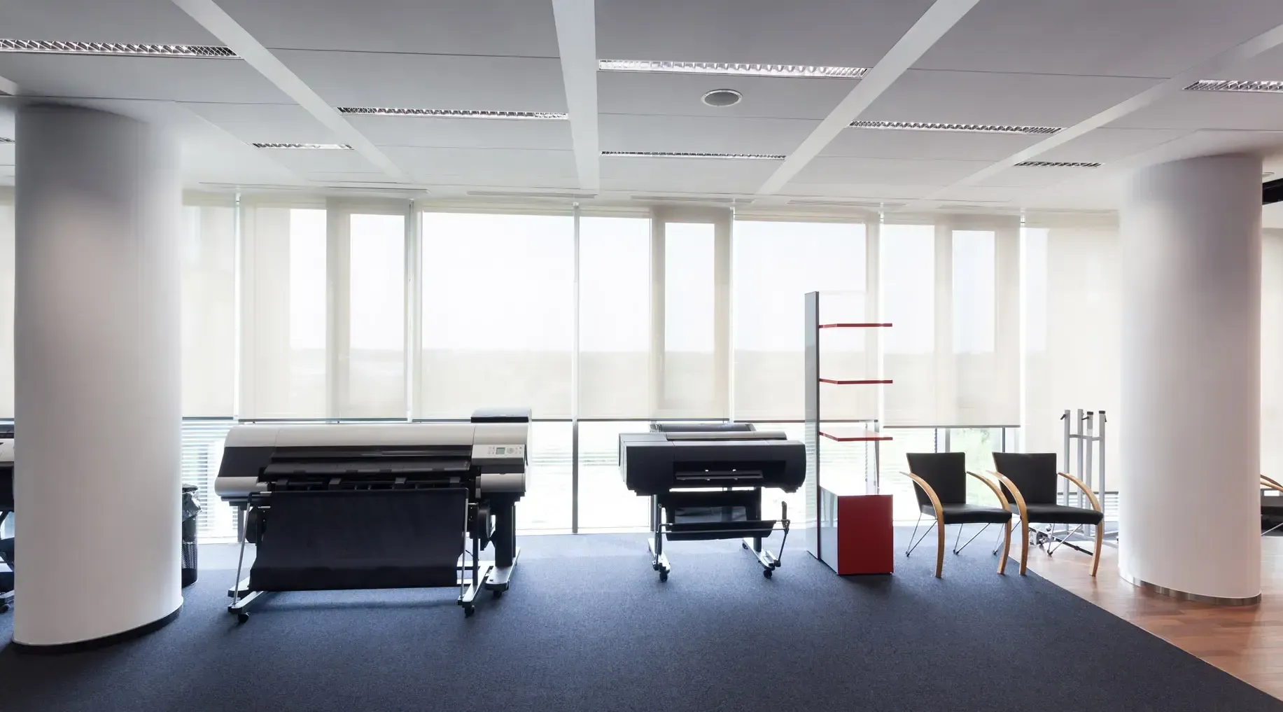 Ein großer Raum mit vielen Fenstern und Stühlen