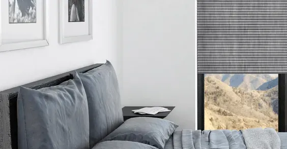 Ein Schlafzimmer mit einem Bett und einem Fenster mit Bergen im Hintergrund.