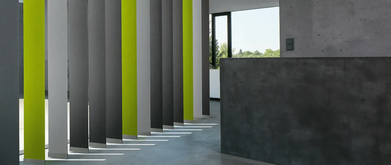 Ein Flur mit einer Reihe vertikaler Jalousien an den Wänden.