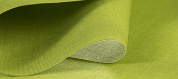 Eine Nahaufnahme eines Stückes grünen Stoffes auf einem Tisch.