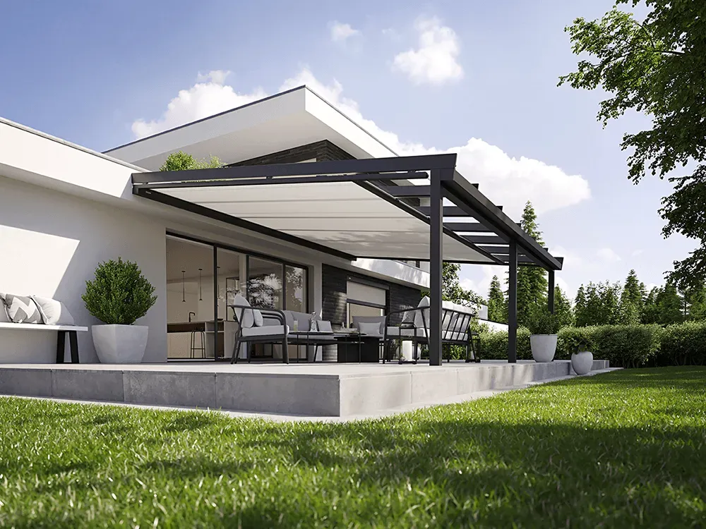 Ein weißes Haus mit einer Pergola und einer Wiese davor.