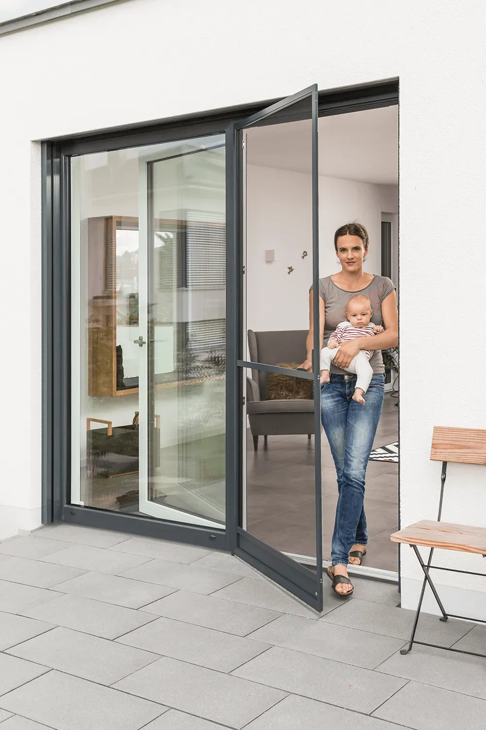 Eine Frau hält ein Baby vor einer Glasschiebetür.