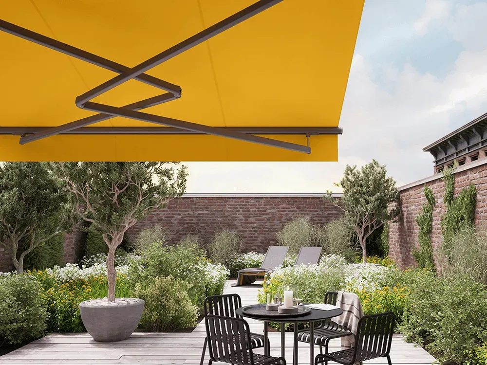 Eine gelbe Markise überdacht eine Terrasse mit einem Tisch und Stühlen.