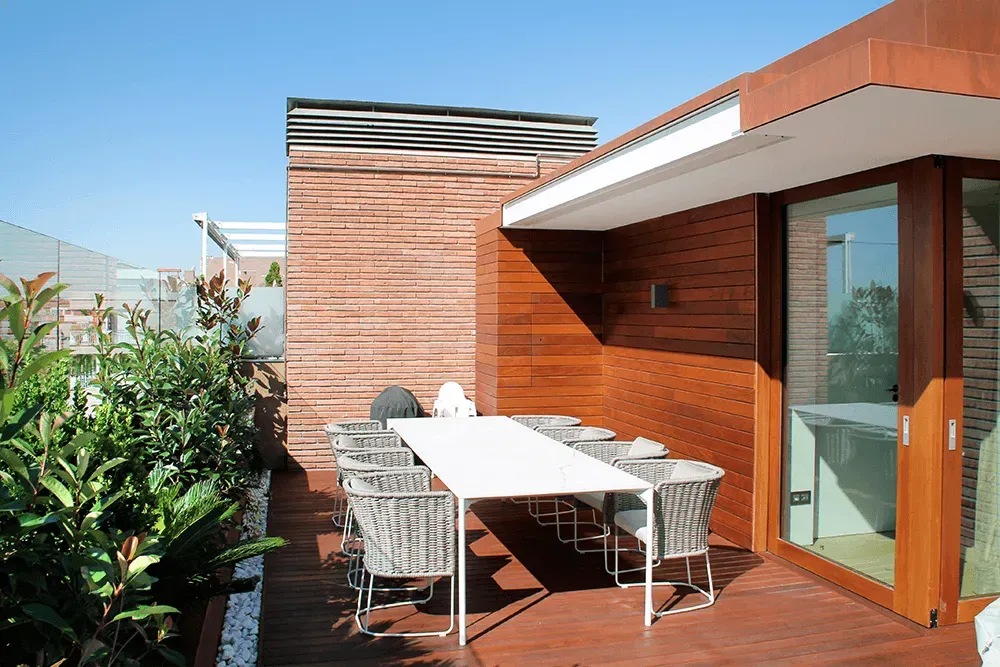 Eine Holzterrasse mit Tisch und Stühlen darauf