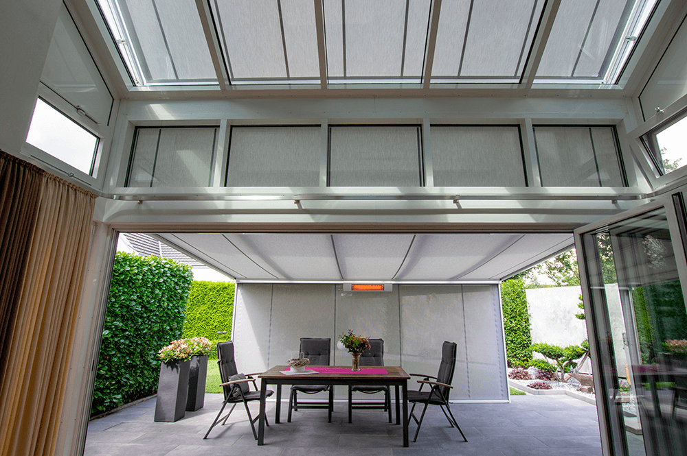 Eine Terrasse mit Tisch und Stühlen unter einem Baldachin.