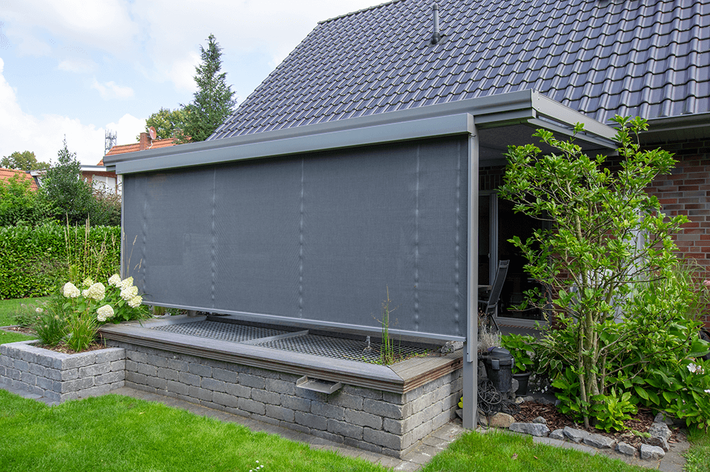 Ein Haus mit einer grauen Markise an der Seite.