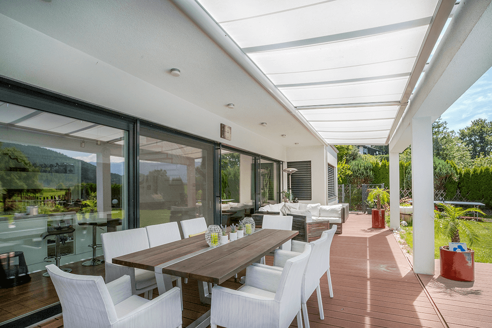 Eine Terrasse mit Tisch und Stühlen unter einem Baldachin.