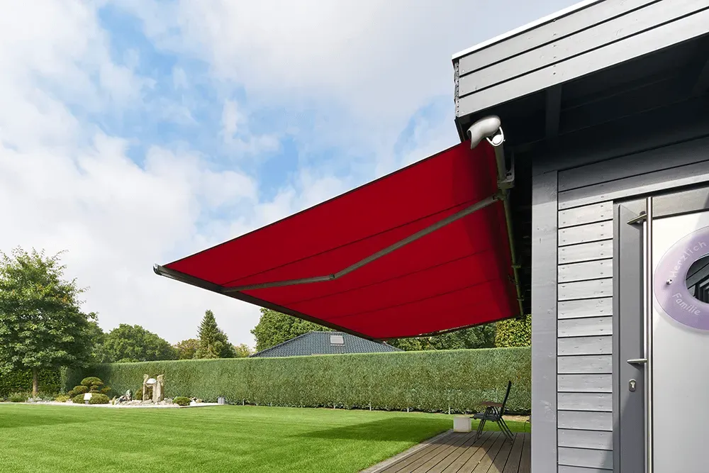 Eine rote Markise hängt an der Seite eines Gebäudes
