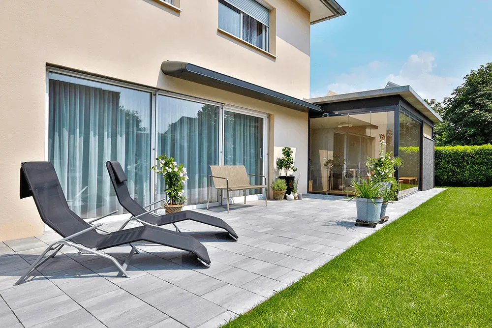 Auf der Terrasse vor dem Haus befinden sich zwei Liegestühle.