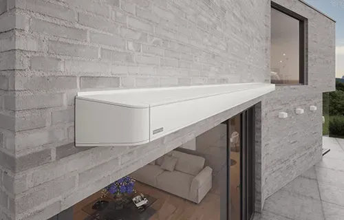 An der Seite eines Backsteingebäudes ist eine weiße Markise angebracht.