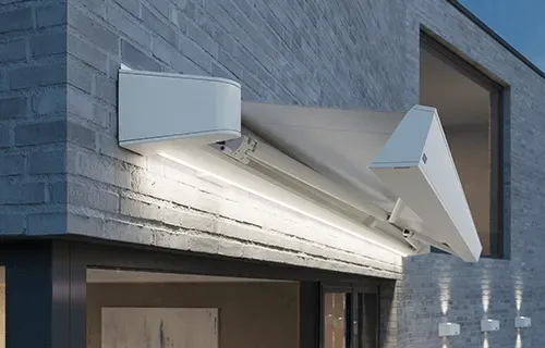 An der Seite eines Backsteingebäudes befindet sich eine weiße Markise.