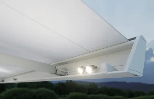 Eine weiße Markise mit zwei daran befestigten Lichtern.