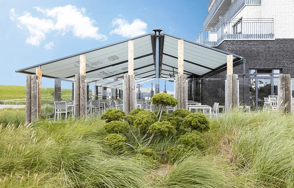 Ein Restaurant mit Tischen und Stühlen unter einem Baldachin