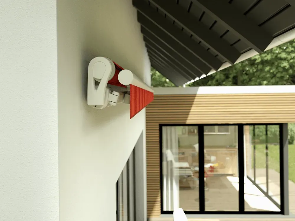 Eine rote Markise hängt an der Seite eines Hauses