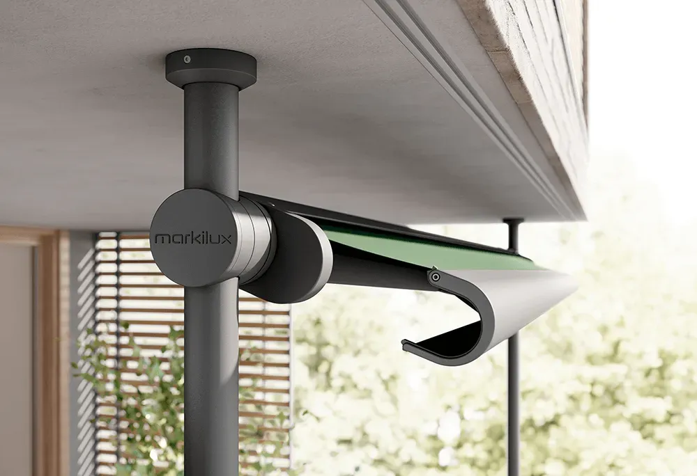 Eine grüne Markise hängt von der Decke eines Balkons.