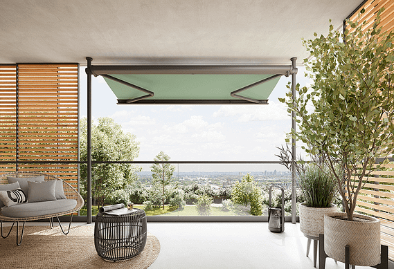 Ein Balkon mit grüner Markise und Blick auf die Stadt.