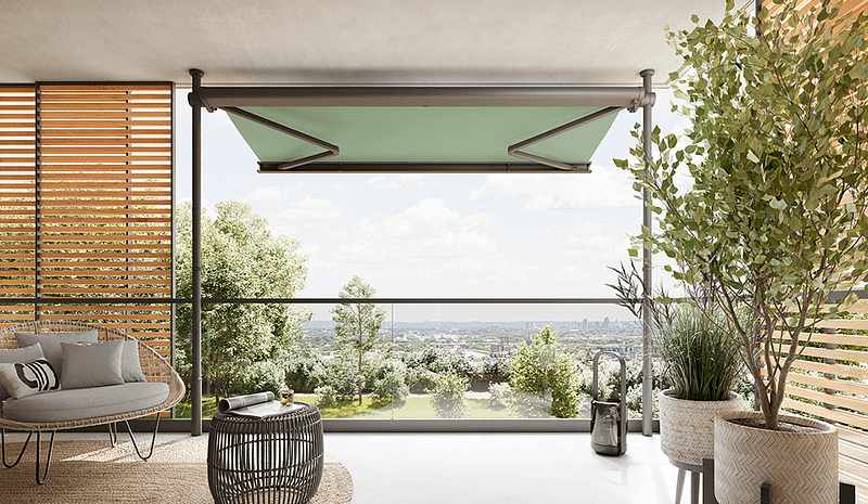 Ein Balkon mit grüner Markise und Blick auf die Stadt.
