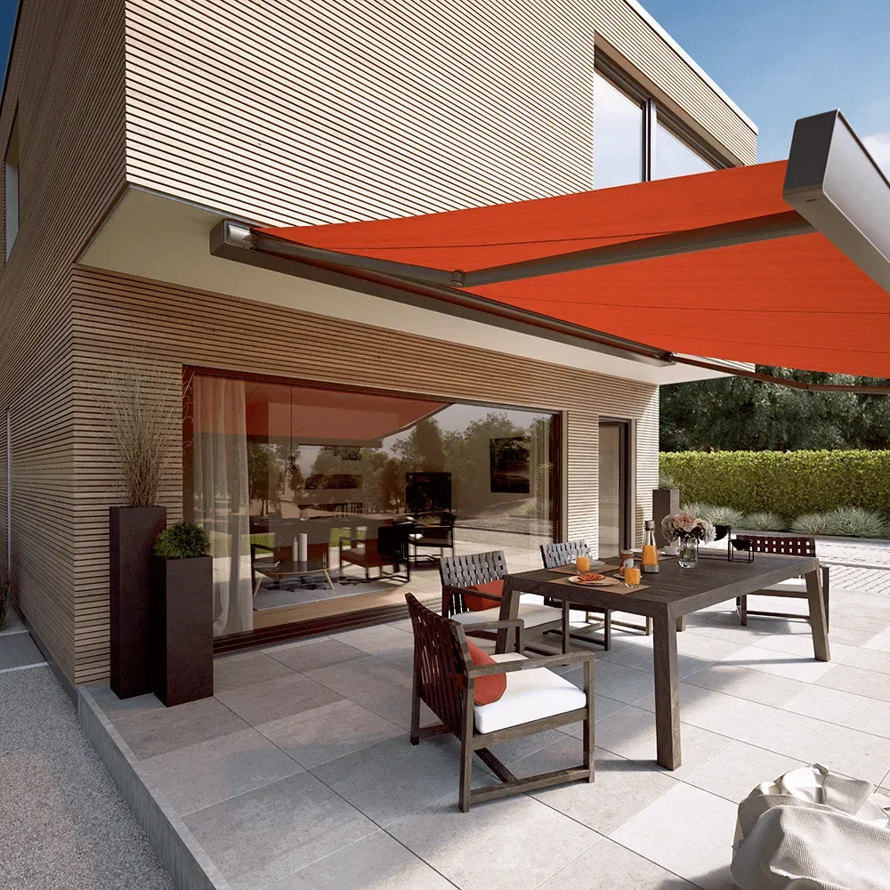 Eine Terrasse mit Tisch und Stühlen unter einer Markise