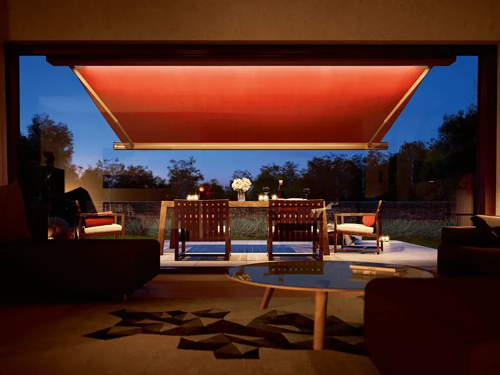 Ein Wohnzimmer mit einer roten Markise über einem Tisch und Stühlen
