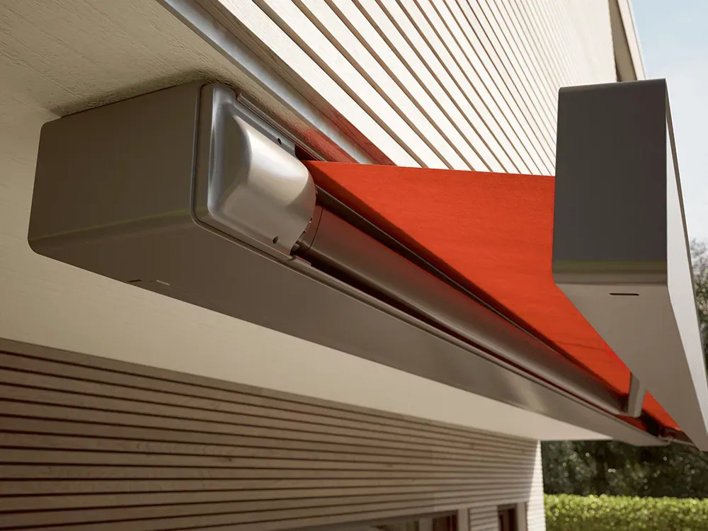 Eine rote Markise hängt an der Seite eines Gebäudes