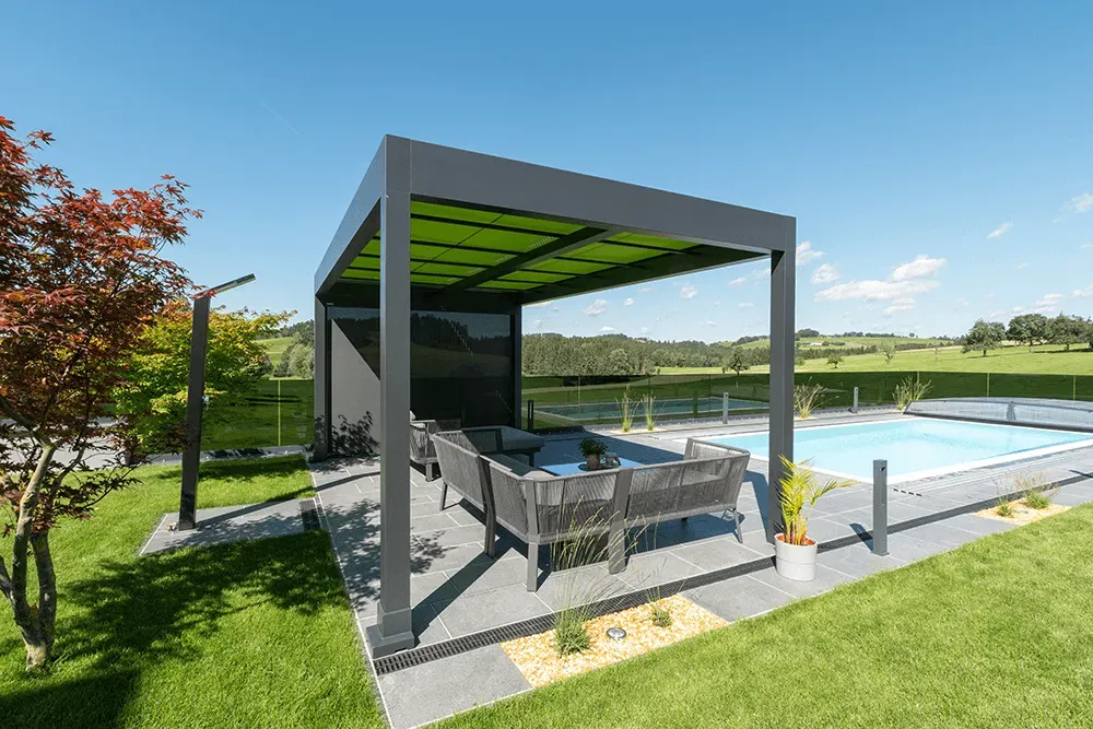 Eine Pergola steht neben einem Swimmingpool in einem Hinterhof.