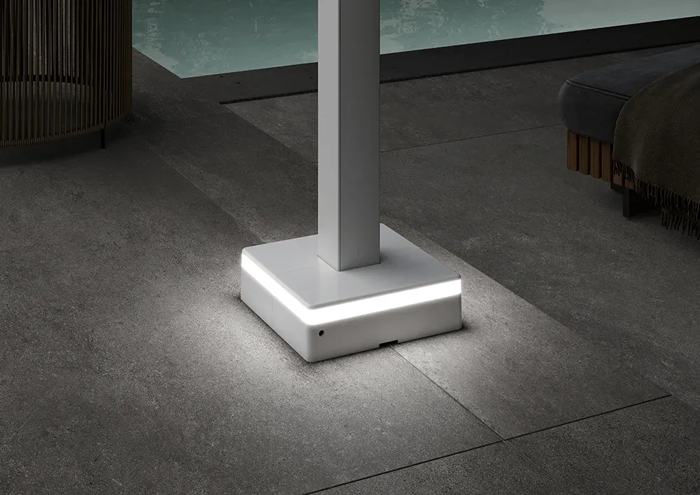 Eine weiße Lampe steht auf einem gefliesten Boden neben einem Pool.