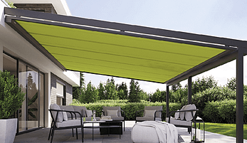 Eine Terrasse mit einer grünen Markise und einem Sofa und Stühlen darunter.
