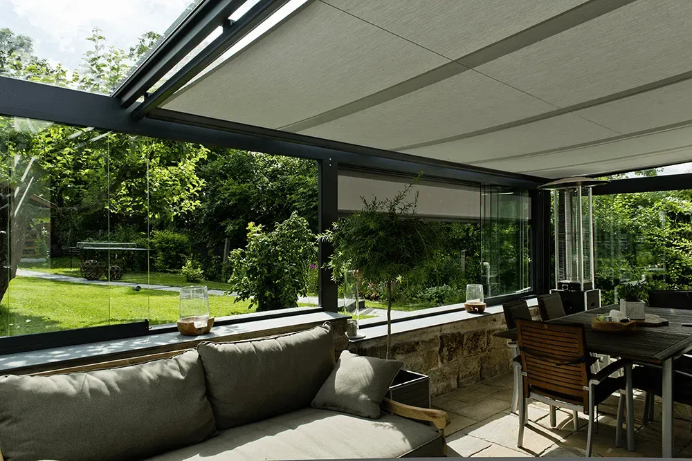 Eine Terrasse mit einer Couch und einem Tisch und Stühlen